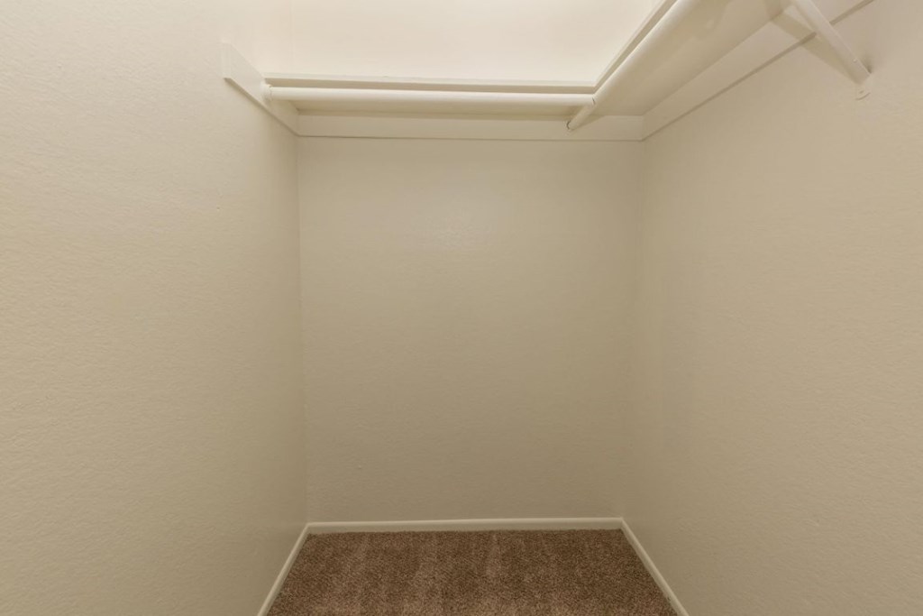 a small room with a carpet and a white wall