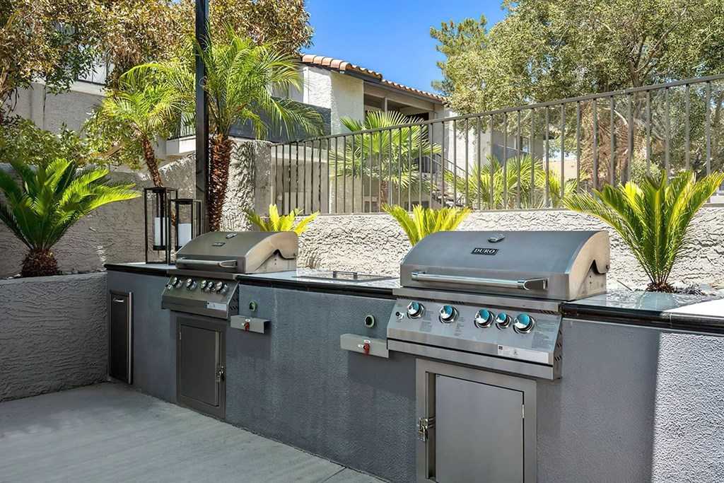 a backyard with a grill and two bbqs