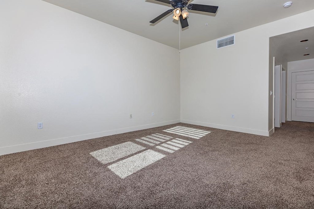 a room with carpet and a ceiling fan