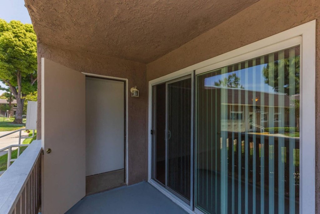 a balcony with a sliding glass door and a patio
