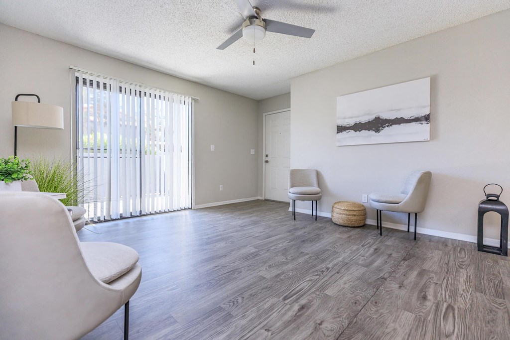 a living room with white furniture and a ceiling fan