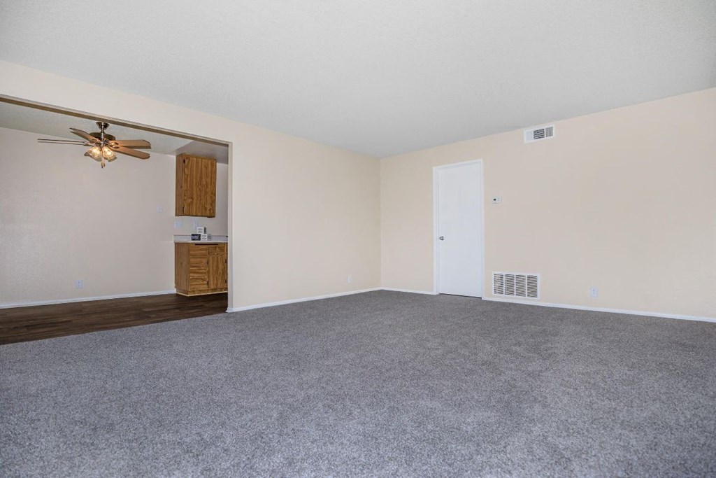 A room with a ceiling fan and a door.