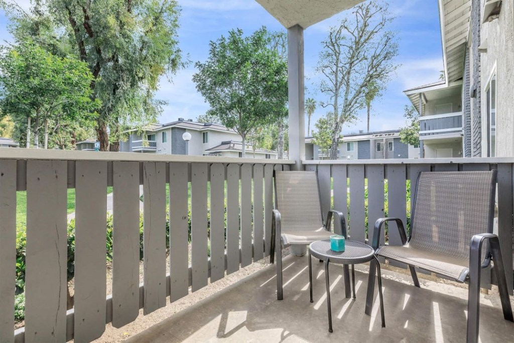 a patio with two chairs and a table on a balcony