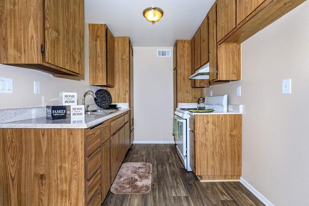 A kitchen with wooden cabinets and a white dishwasher.