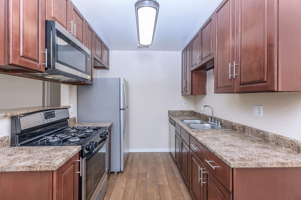 a kitchen with wood cabinets and stainless steel appliances and granite counter tops