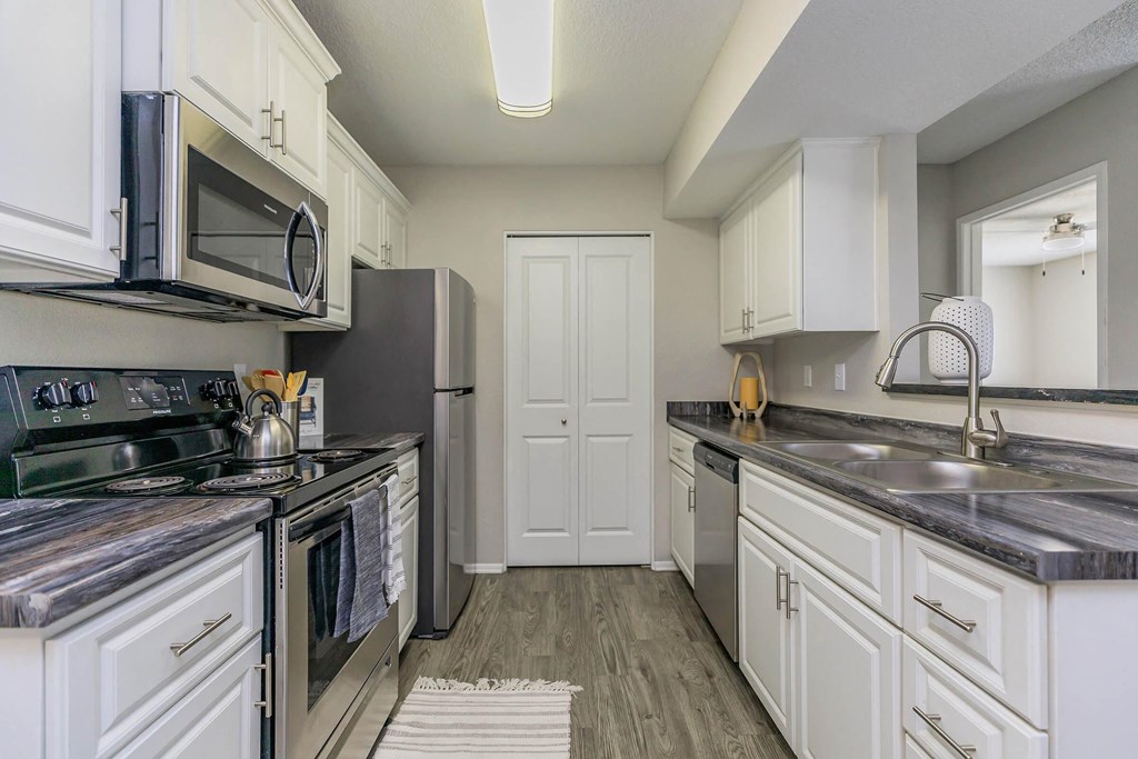 a kitchen with stainless steel appliances and white cabinets
