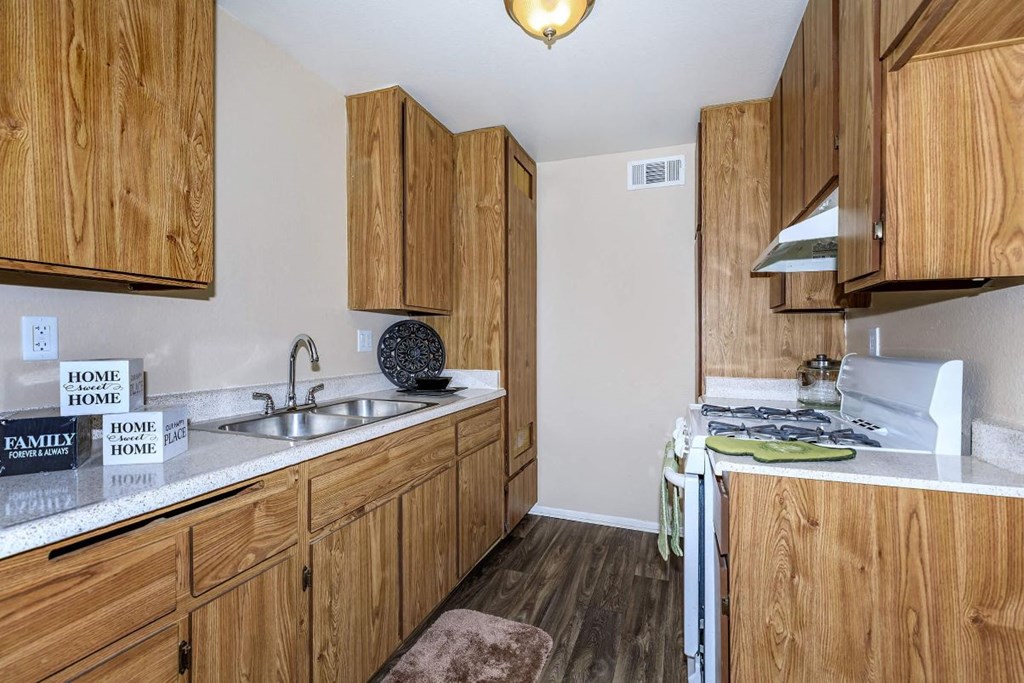 A kitchen with wooden cabinets and a white countertop.