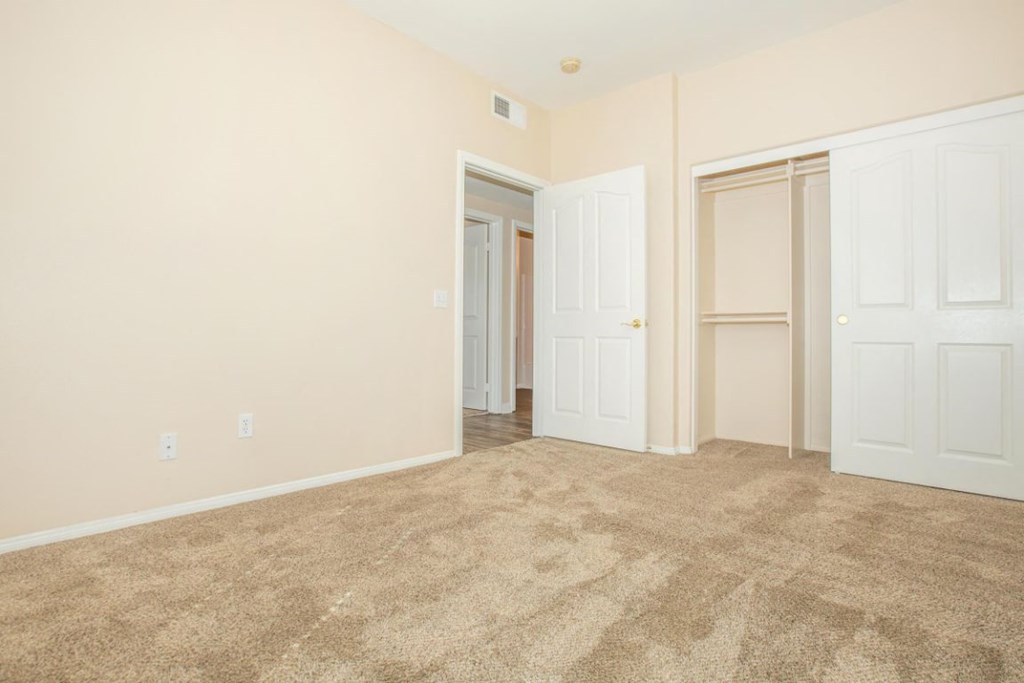 A room with carpeted floor and white doors.