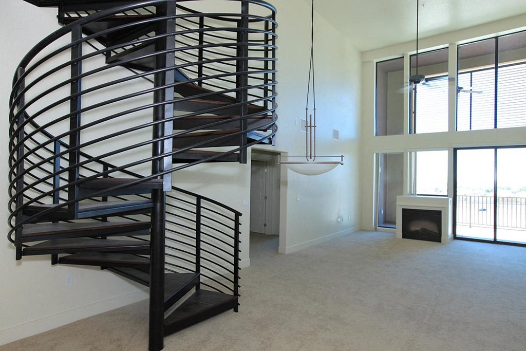 a spiral staircase in a living room with a fireplace