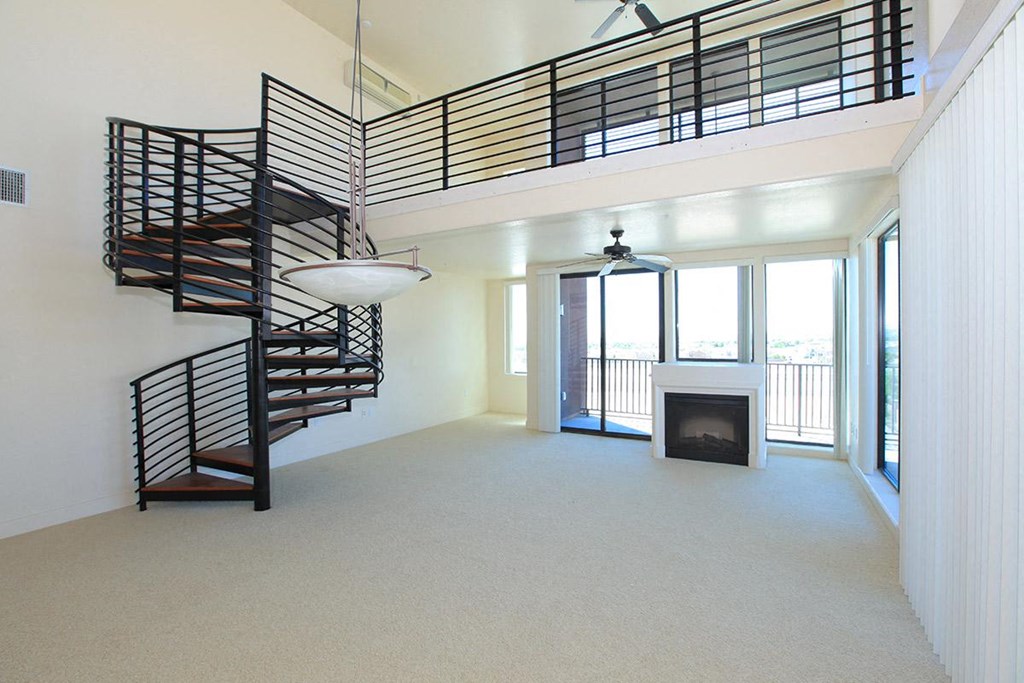 a spiral staircase in a living room with a fireplace