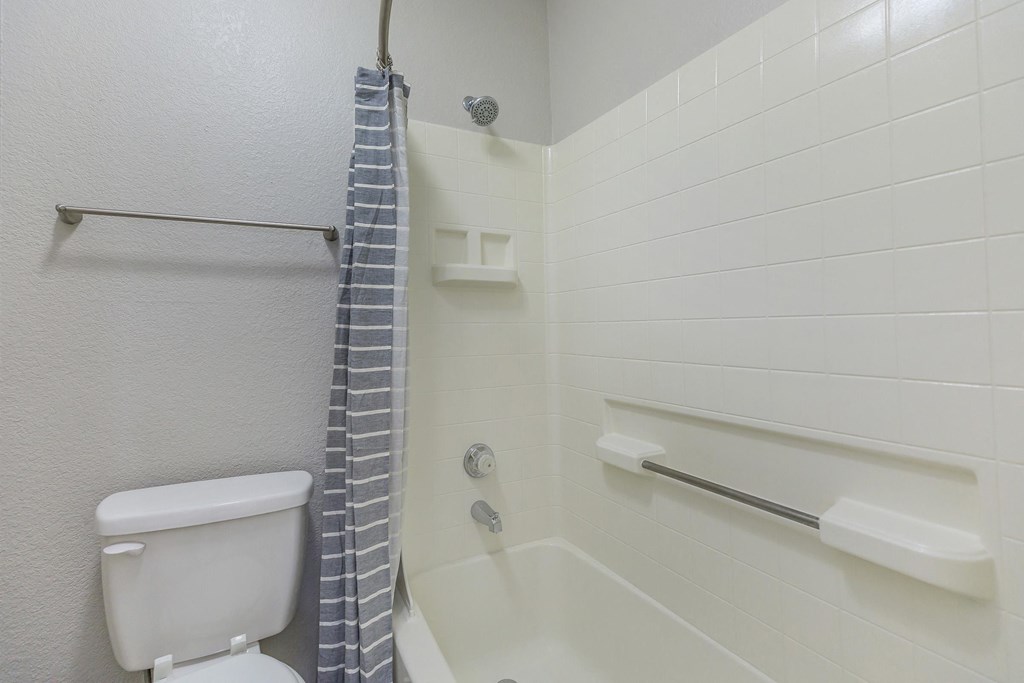 a bathroom with a toilet and a shower with a shower curtain