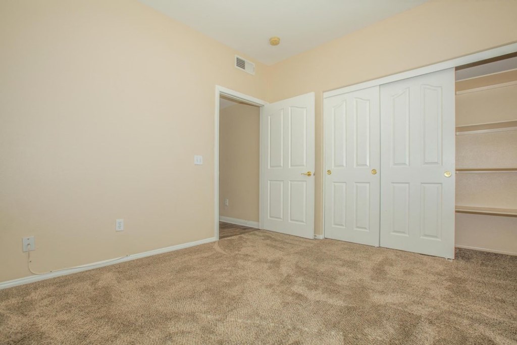 A room with a carpeted floor and white doors.