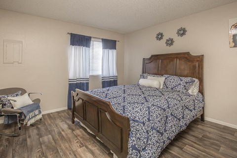 a bedroom with a bed and a chair and a window