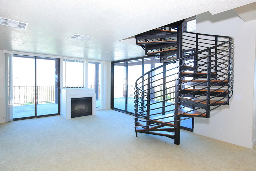 a spiral staircase in a living room with a fireplace