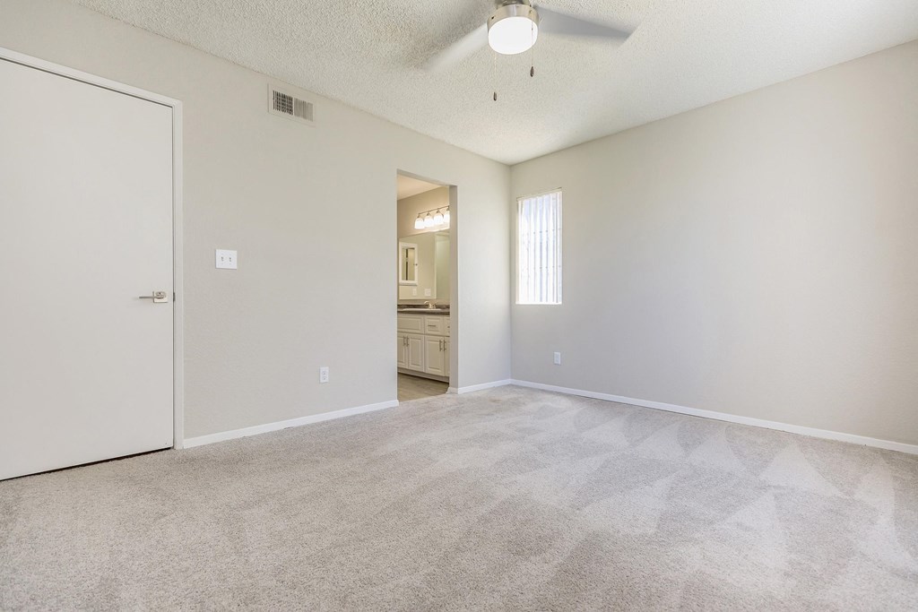 an empty living room with a door to a bathroom