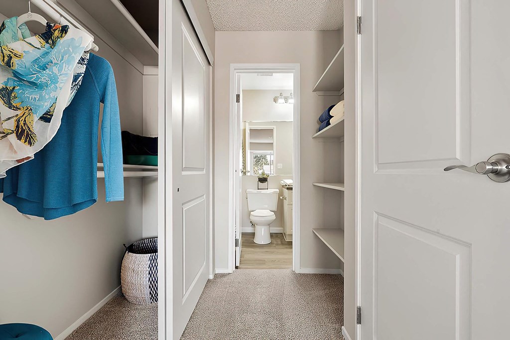 a walk in closet with a view of a bathroom