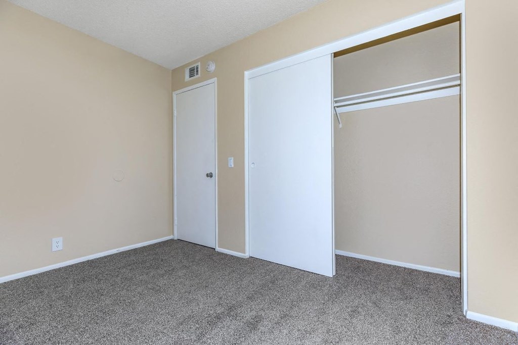 A room with a white door and a white closet door.
