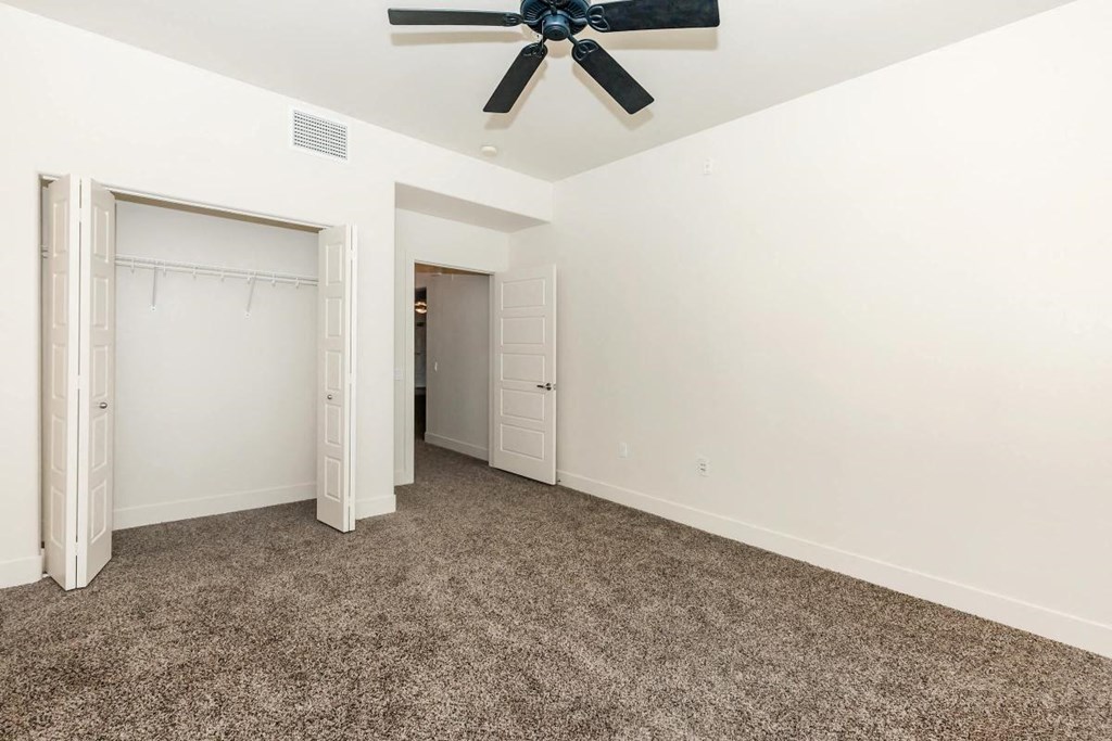 a bedroom with carpet and a ceiling fan
