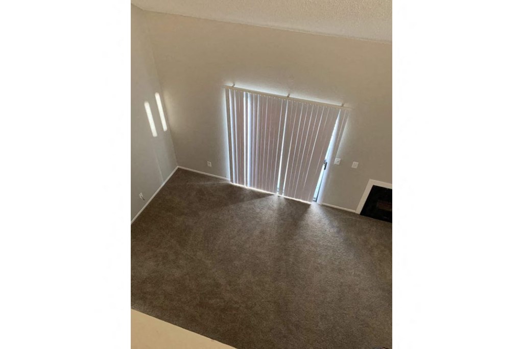 an empty living room with a door to a closet