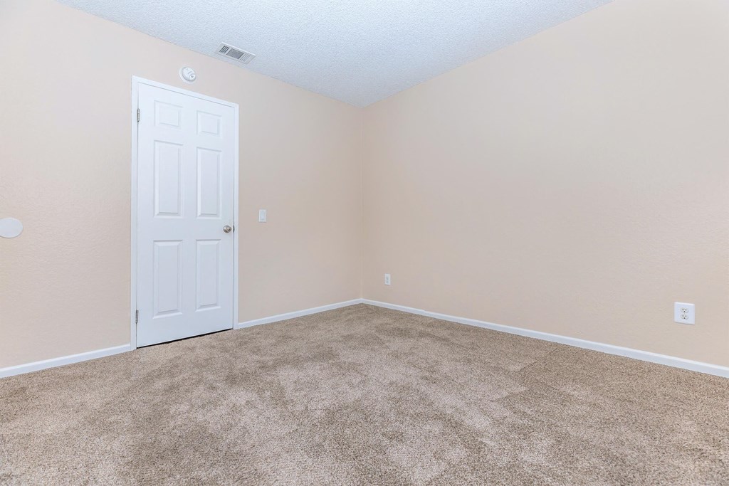 an empty room with carpet and a white door