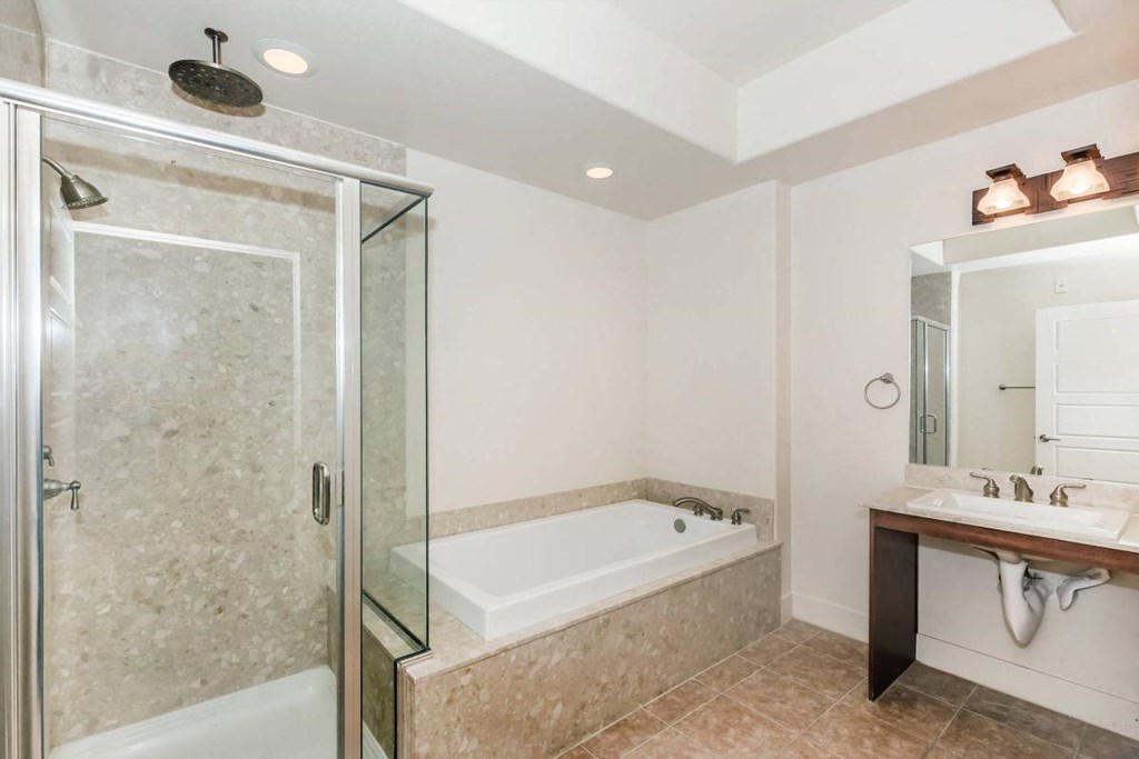 a bathroom with a tub and a shower and a sink