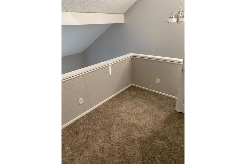 a bedroom with a carpeted floor and gray walls