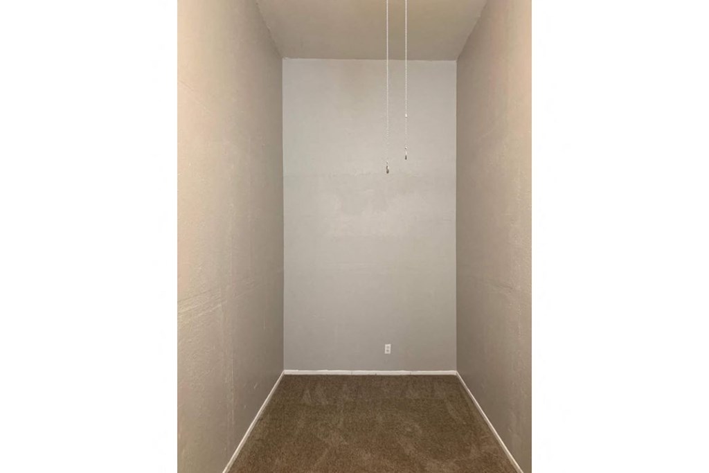 an empty room with white walls and a carpet