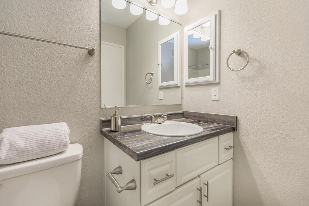 a white bathroom with a sink and a mirror