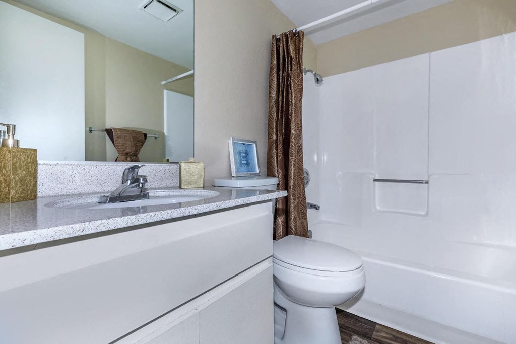 A white toilet sits next to a sink in a bathroom.