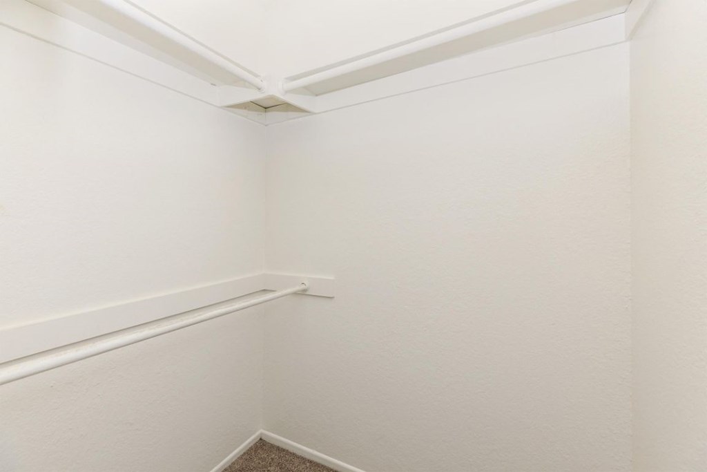 a white room with a rail and a white wall