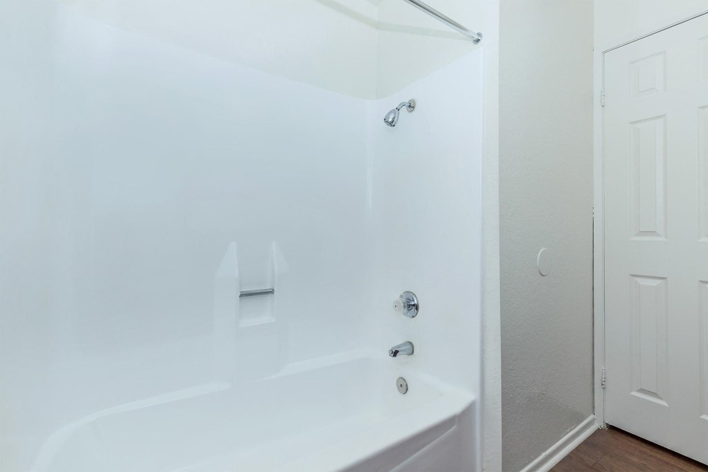 a white bathroom with a tub and a shower