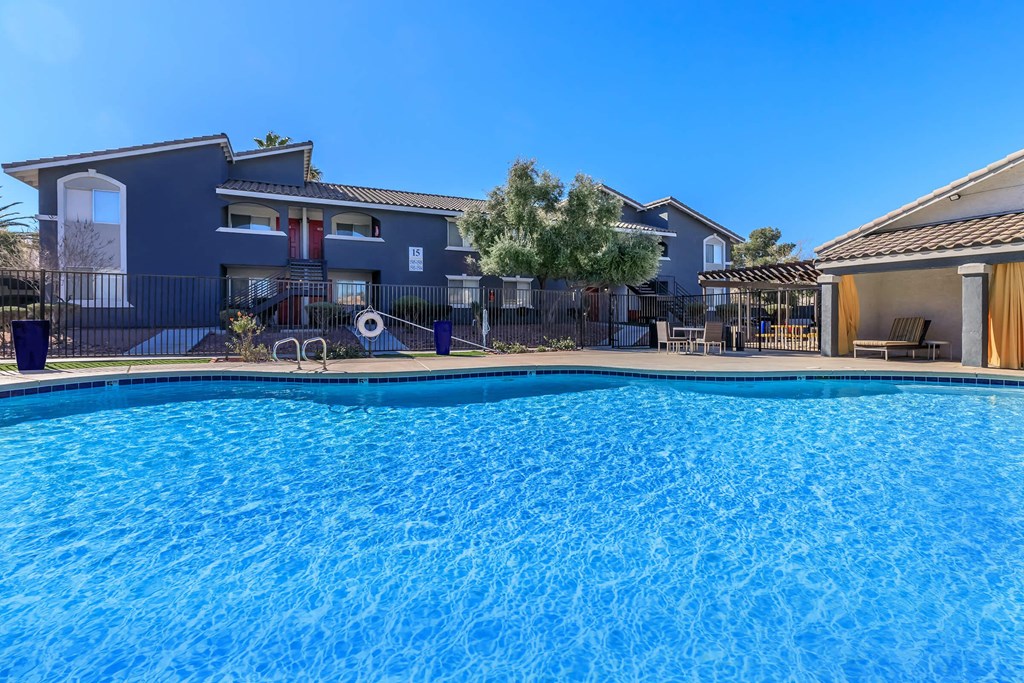 a large swimming pool with a house in the background