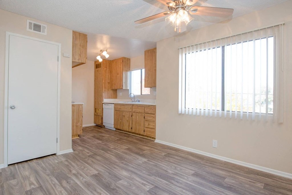 A room with a ceiling fan and a window with blinds.