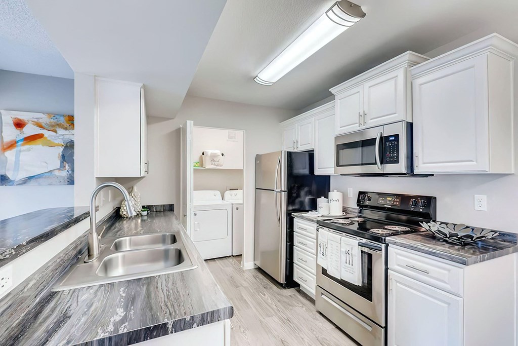 a kitchen with stainless steel appliances and white cabinets