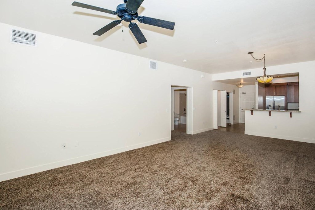 a living room with carpet and a ceiling fan