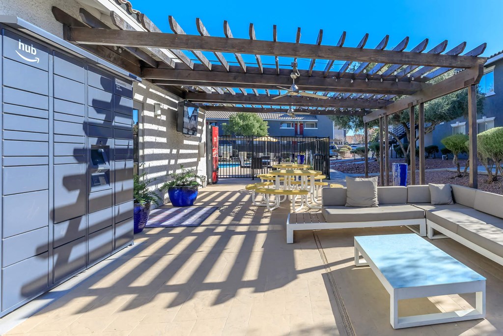 a patio with couches and tables under a pergola