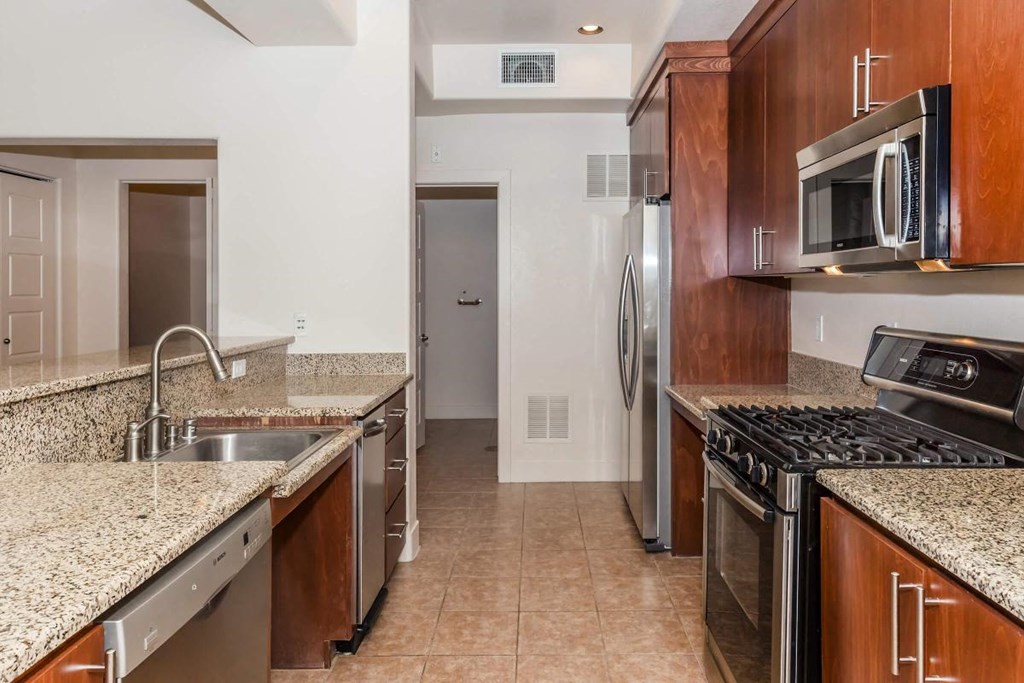 a kitchen with granite counter tops and stainless steel appliances