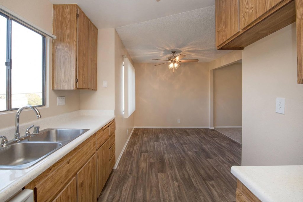 A kitchen with wooden cabinets and a white counter top.
