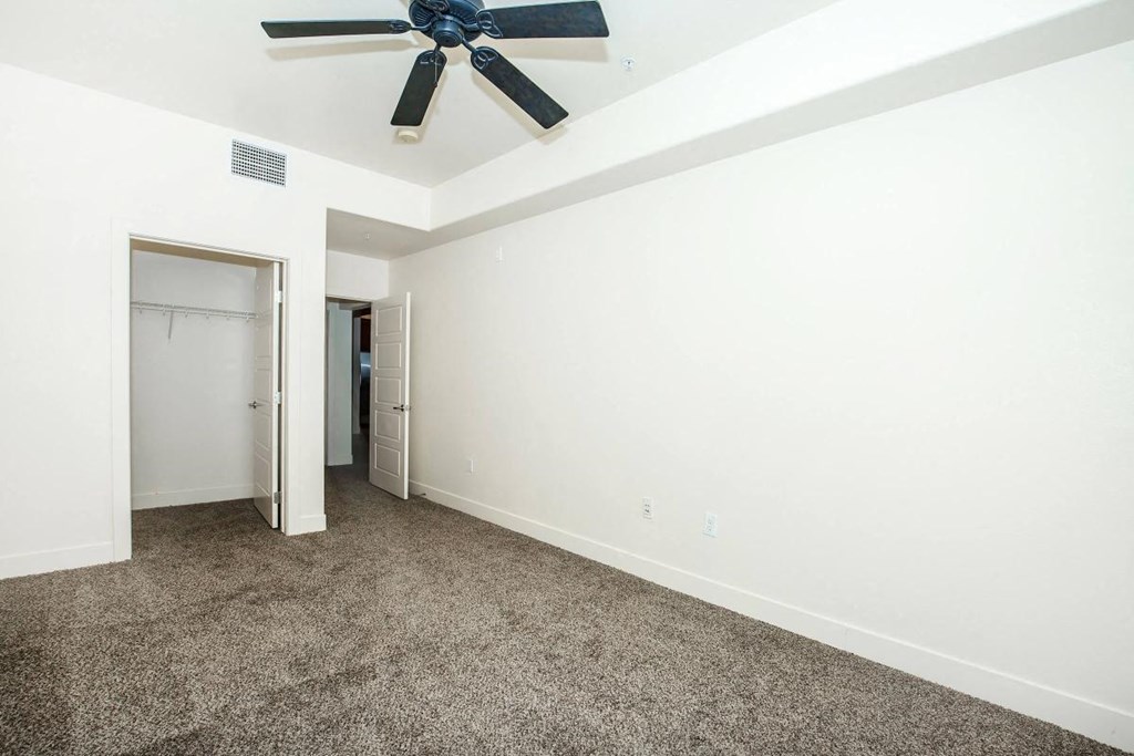 a bedroom with carpet and a ceiling fan