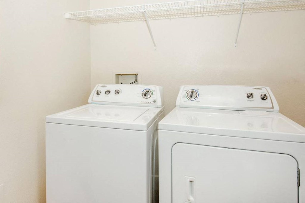 two washes and a dryer in a white room
