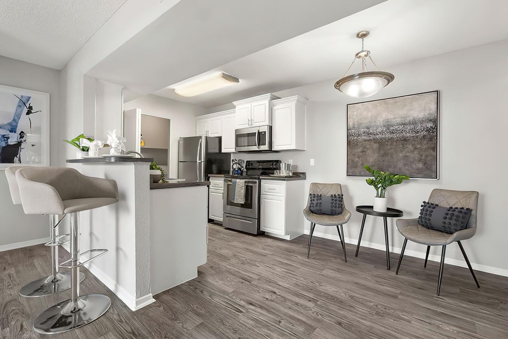 an open kitchen and living room with a bar and stools