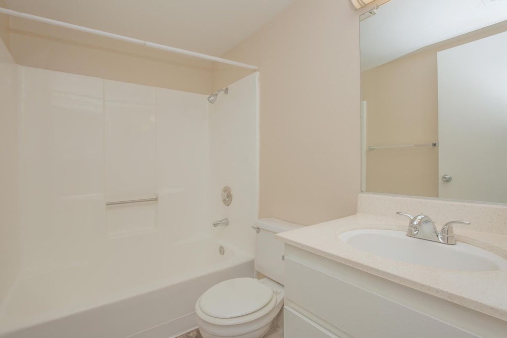A white toilet sits next to a white sink in a bathroom.