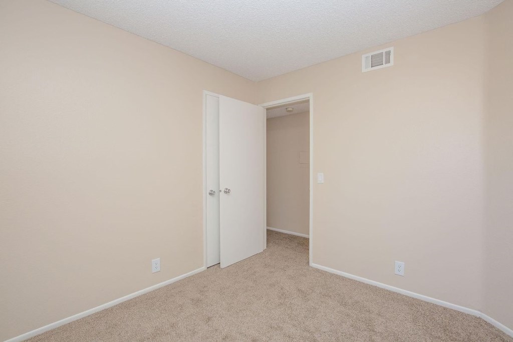 A room with a carpeted floor and a white door.