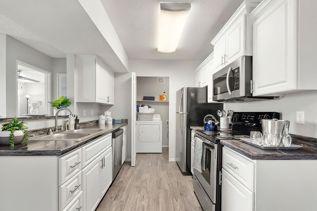a kitchen with white cabinets and stainless steel appliances