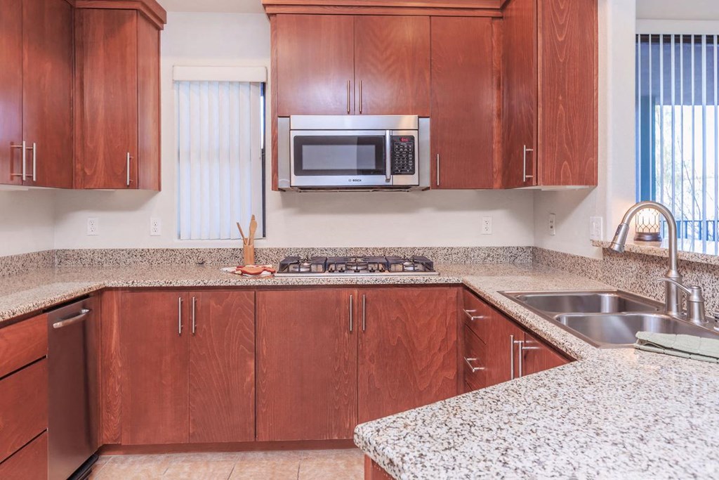 a kitchen with granite counter tops and wooden cabinets