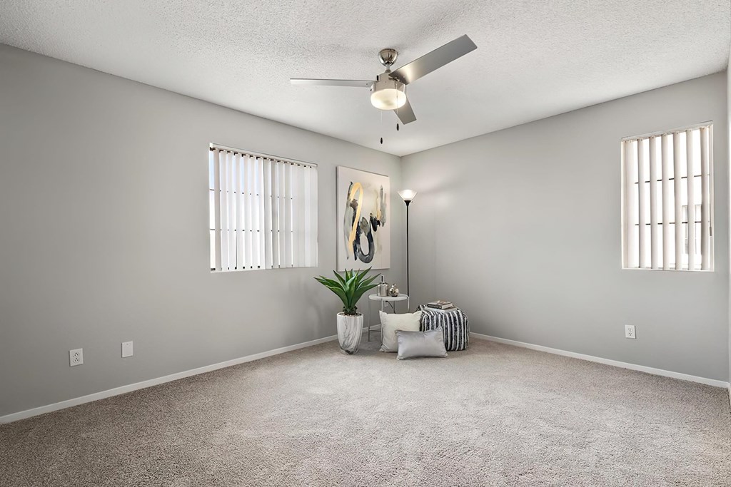 an empty living room with a ceiling fan