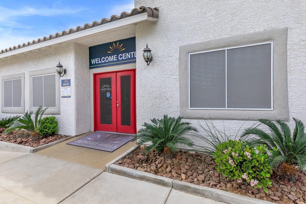a building with a red door and a sign that reads welcome center