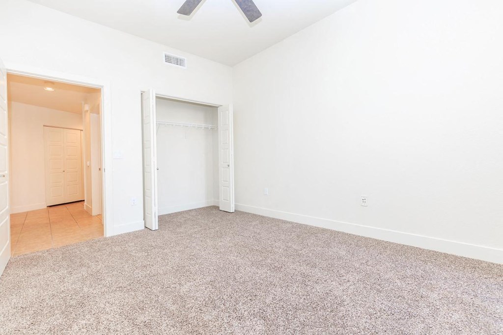 an empty living room with a door to a closet