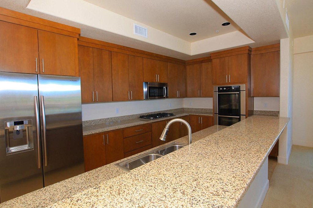 a kitchen with a granite counter top and a stainless steel refrigerator