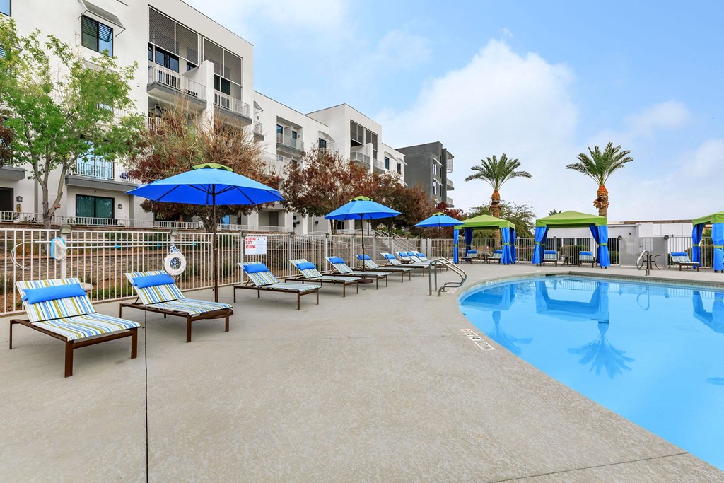 a swimming pool with lounge chairs and umbrellas at the resort